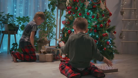two-children-running-towards-their-presents-on-Christmas-morning.-Two-boys-in-pajamas-running-to-look-at-the-gifts-under-the-Christmas-tree.-High-quality-4k-footage
